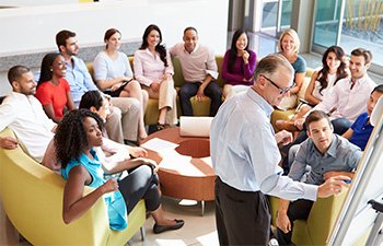 Employee meeting brainstorm Image of employees sitting in circle during brainstorming session